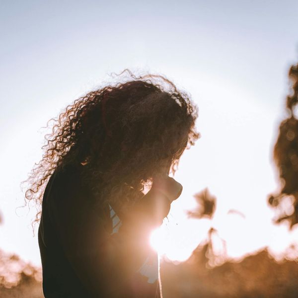 Person meditating in a calm natural environment at sunrise.